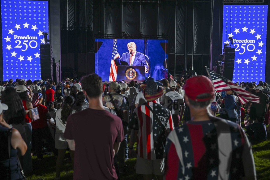 epa13088215 Spectators watch US President Donald J. Trumps address prior to the Independence Day fireworks show on the National Mall in Washington, DC, USA, 04 July 2026. Todays 250th Independence D ...