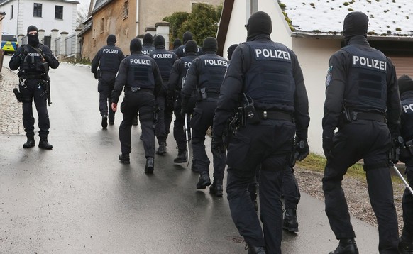 07.12.2022, Th�ringen, Saaldorf: Einsatzkr�fte der Polizei laufen zum Jagdschloss Waidmannsheil, w�hrend der Durchsuchung durch die Polizei. Die Bundesanwaltschaft hat am Mittwochmorgen mehrere Mensch ...