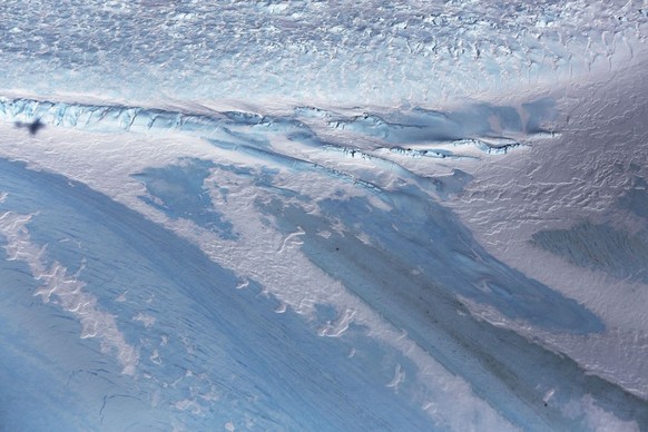 UNSPECIFIED, ANTARCTICA - OCTOBER 31: The shadow of NASA&#039;s Operation IceBridge research aircraft (L) is cast over blue ice, in the Antarctic Peninsula region, on October 31, 2017, above Antarctic ...