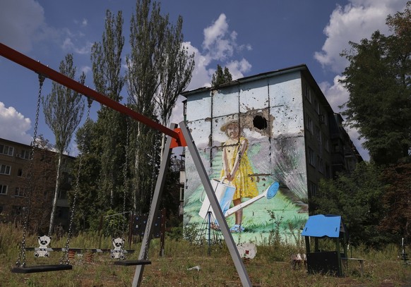 epa10825907 A damaged mural is seen on the Mural alley in Avdiivka settlement near a frontline in Donetsk region, Ukraine, 28 August 2023, amid Russia's ongoing invasion. About 1,600 locals still ...