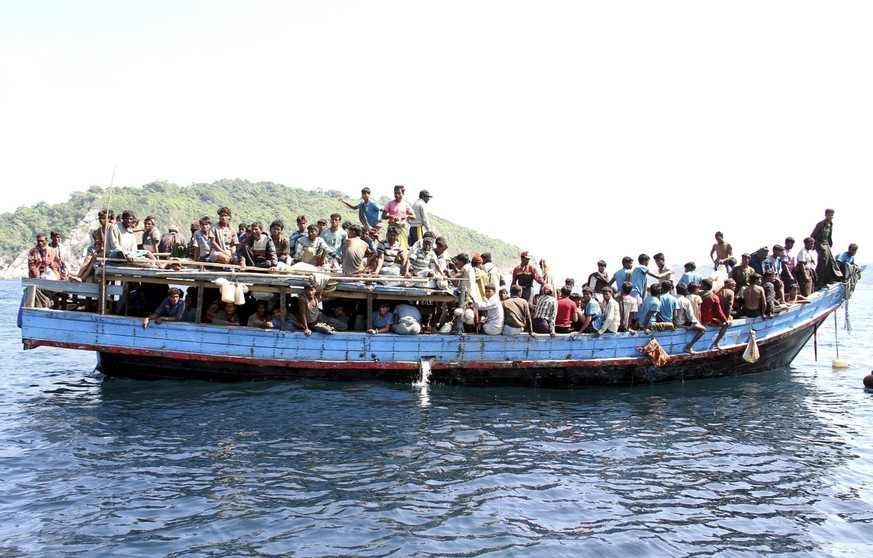 epa03560484 Ethnic Rohingya refugees from Myanmar gather on a boat as they are being rescued by Thai Navy officers before they head to Malaysia, at the Andaman coast, Phuket island, southern Thailand, ...