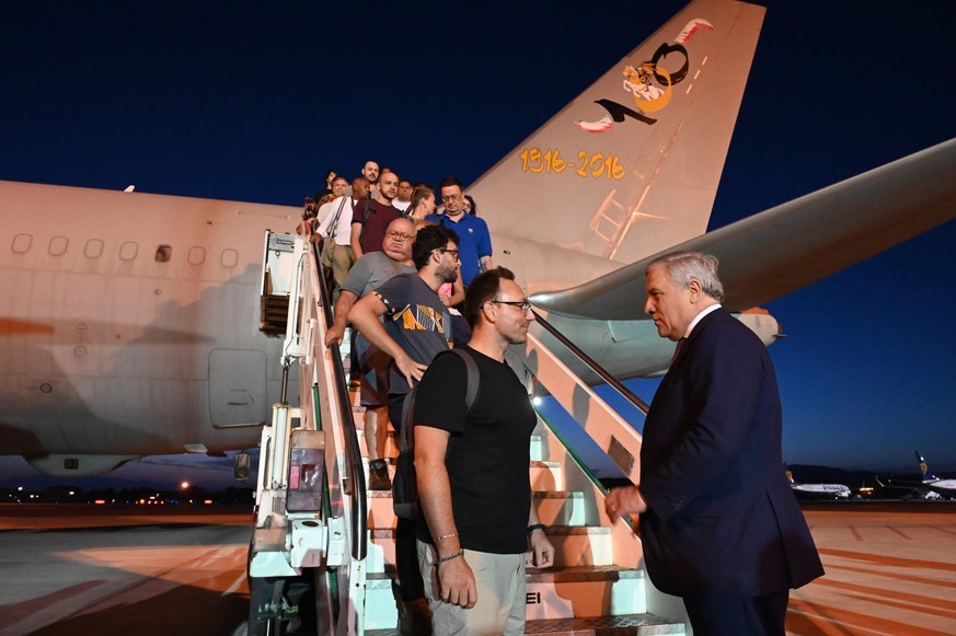 Le ministre italien des Affaires étrangères Antonio Tajani salue les passagers américains d'un avion parti du Niger.