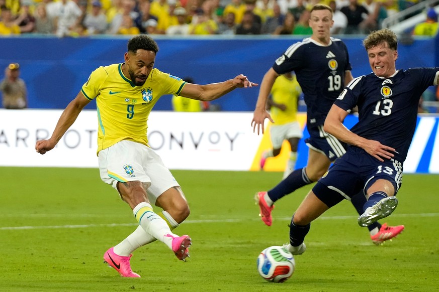 Brazil's Matheus Cunha (9) shoots and scores their third goal against Scotland's Jack Hendry (13) during the World Cup Group C soccer match between Scotland and Brazil in Miami Gardens, Fla. ...