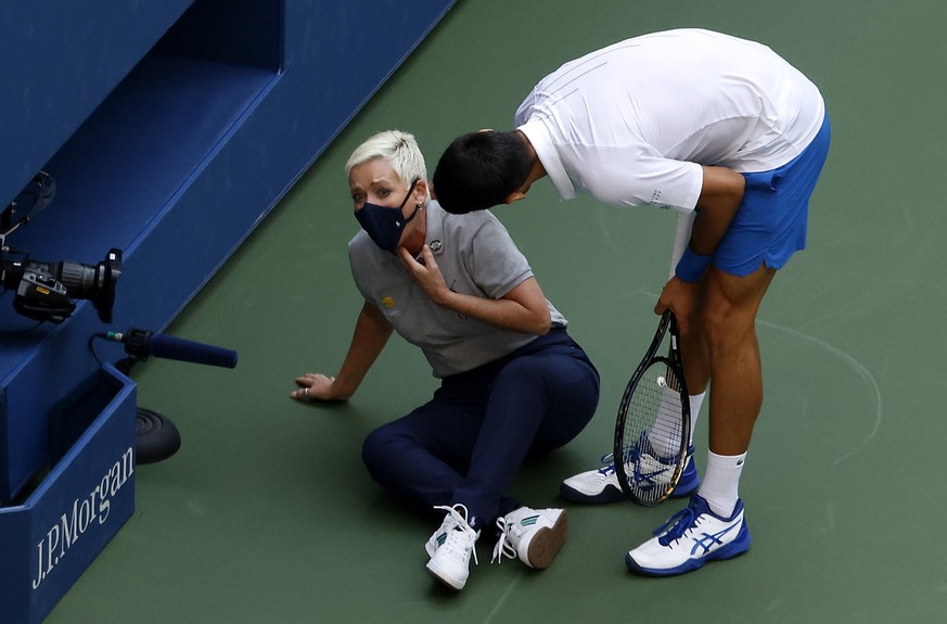 epa08767156 YEARENDER 2020 .SPORTS..Novak Djokovic of Serbia (R) tries to help a linesperson after hitting her with a ball in the throat during his match against Pablo Carreno Busta of Spain on the se ...