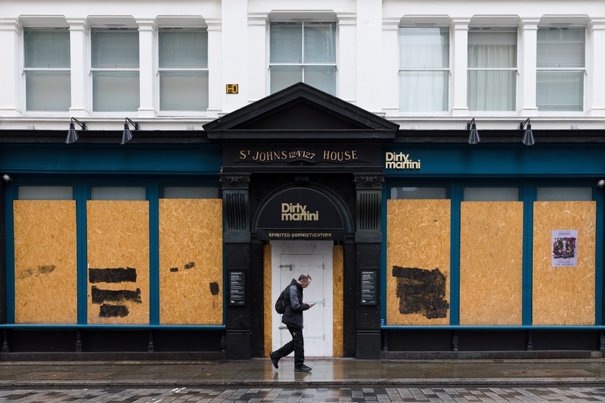 epa09659575 A closed and boarded up former pub in the City of London, Britain, 29 December 2021. The hospitality sector has called on the British Chancellor to provide financial support to the industr ...