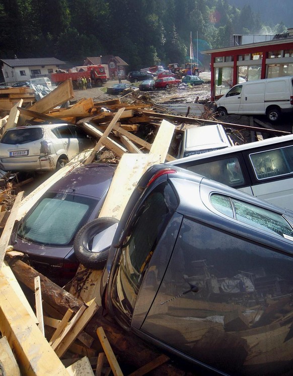 Cars rest scattered around at the yard of a destroyed car dealership in Au after flood waters hit the town, Austria, Wednesday, 24 August 2005. At least nine people had been killed in Austria and Swit ...