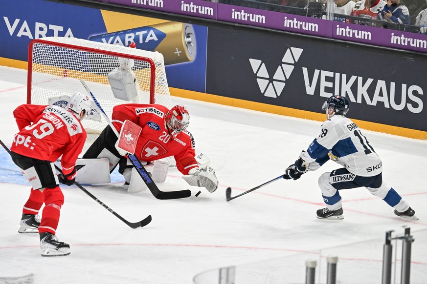 epa12508186 Swizterland&#039;s goalkeeper Reto Berra (C) and Finland&#039;s Vili Saarijarvi (R) in action during the Euro Hockey Tour ice hockey match between Switzerland and Finland in Tampere, Finla ...