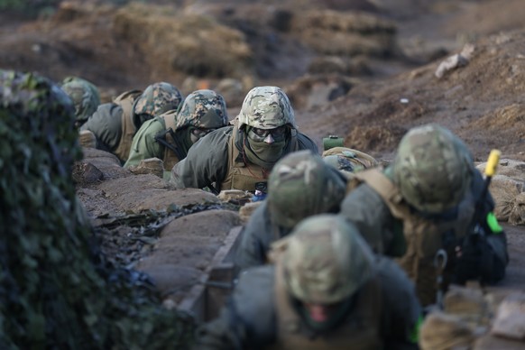 epa10470069 Ukrainian military personal undergo combat training in a trench with British troops from 11 Security Force Assistance Brigade at an undisclosed location in England, Britain, 16 February 20 ...