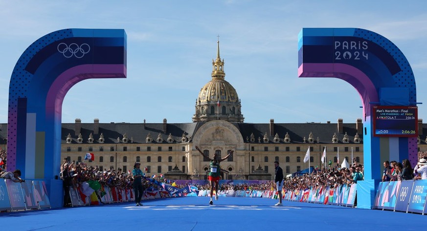 PARIS, FRANCE - AUGUST 10: Tamirat Tola of Team Ethiopia crosses the finish line to win the Gold medal and to break the Olympic Record during the Men&#039;s Marathon on day fifteen of the Olympic Game ...