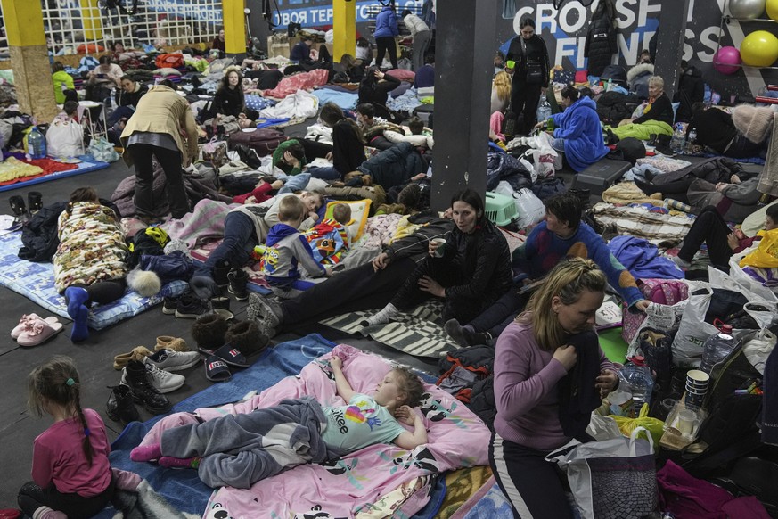 People sit and lie on the floor in the improvised bomb shelter in a sports center, which can accommodate up to 2000 people, in Mariupol, Ukraine, late Sunday, Feb. 27, 2022. Explosions and gunfire tha ...