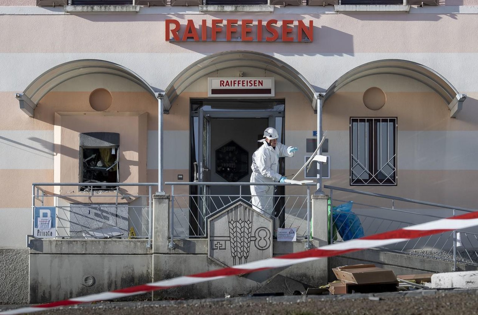 Un agent scientifique de la police devant un distributeur automatique de billets Raiffeisen qui a été dynamité par des inconnus. L&#039;explosion s&#039;est produite à Novaggio dans la nuit du jeudi 1 ...