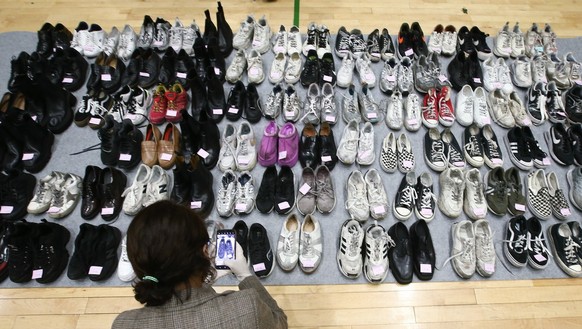 A police officer checks shoes collected from the scene of an stampede, at a multi-purpose gym in Seoul, South Korea, 01 November 2022. According to the National Fire Agency, at least 154 people were k ...