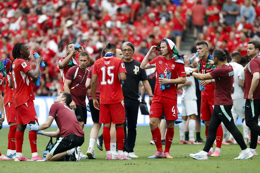Switzerland's head coach Murat Yakin, middle, speaks with the players during a Hydration Break during the World Cup Group B soccer match between Switzerland and Canada at the BC Place stadium in  ...