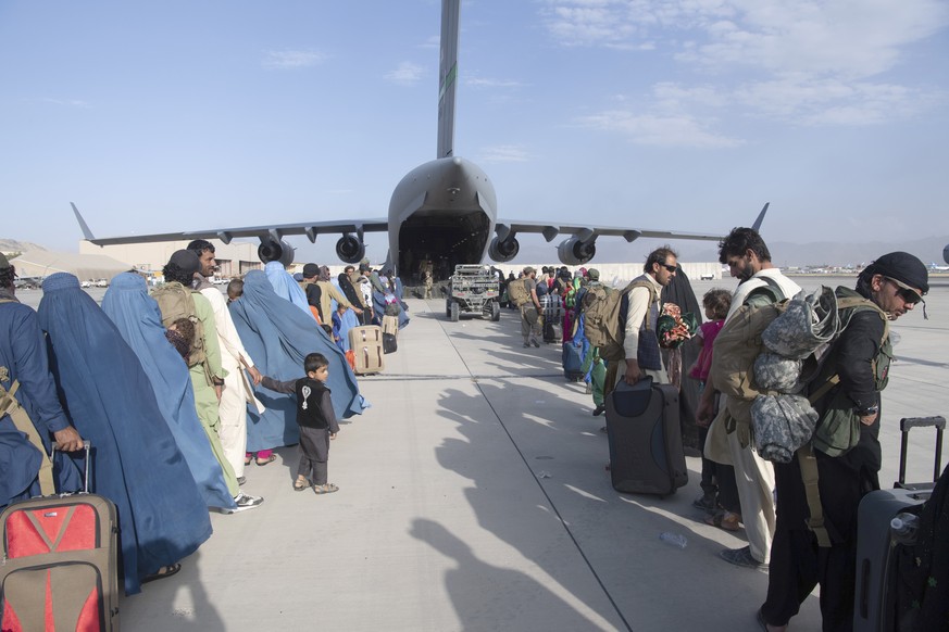 In this image provided by the U.S. Air Force, U.S. Air Force loadmasters and pilots assigned to the 816th Expeditionary Airlift Squadron, load people being evacuated from Afghanistan onto a U.S. Air F ...