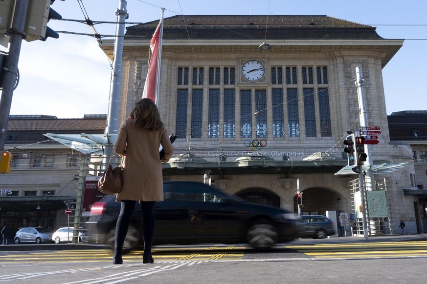 Une femme passe devant le batiment de la Gare CFF de Lausanne lors de la pandemie du virus Coronavirus, (Covid-19) ce lundi 16 mars 2020 a Lausanne. (KEYSTONE/Leandre Duggan)