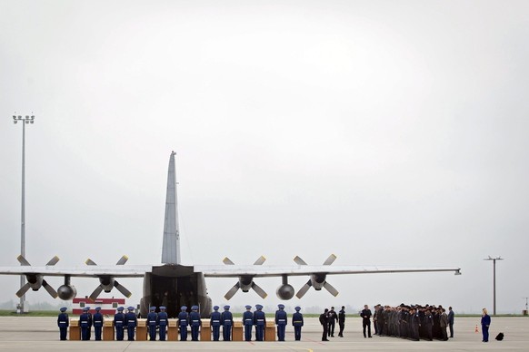 epa04729935 Ukrainian soldiers stand next to coffins containing recently discovered remains of Dutch victims of the MH17 plane crash, as they are loaded onto a Hercules C130 transport aircraft of the  ...