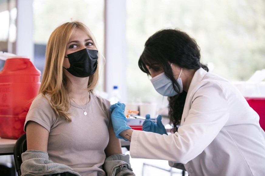 epa09198576 A 12-year-old girl receives a dose of COVID-19 vaccine during a vaccination drive organized by the Annenberg Foundation and Mickey Fine Pharmacy for teenagers aged between 12 and 15 at the ...