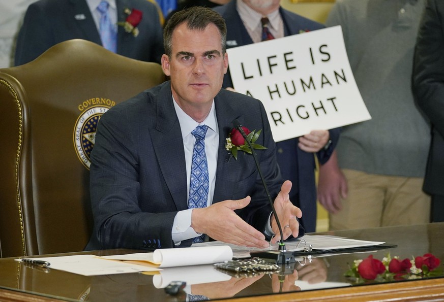 FILE - Oklahoma Gov. Kevin Stitt speaks after signing into law a bill making it a felony to perform an abortion, punishable by up to 10 years in prison, on. April 12, 2022, in Oklahoma City. Stitt on  ...