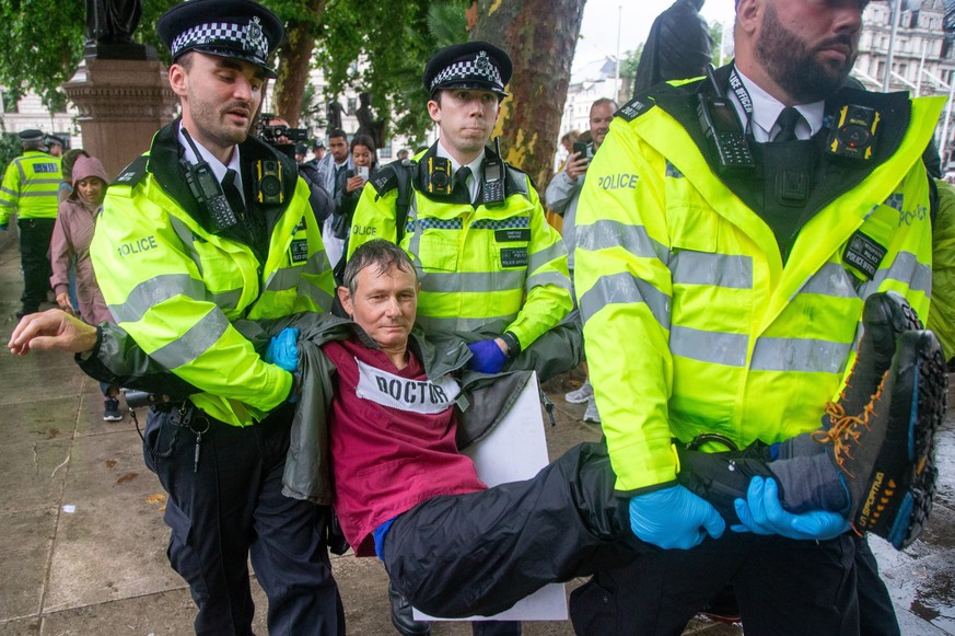 epaselect epa12247435 Police officers detain a protester who was holding a placard with a message supporting Palestine Action group, during the &#039;National March for Palestine&#039; in London, Brit ...