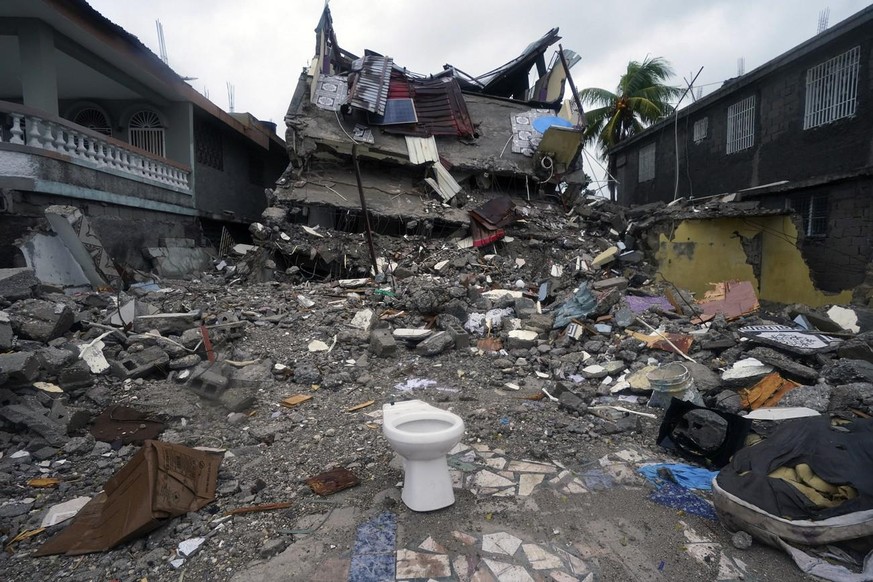 A building lays in ruins three days after a 7.2-magnitude earthquake and the morning after Tropical Storm Grace swept over Les Cayes, Haiti, Tuesday, Aug. 17, 2021. (AP Photo/Fernando Llano)