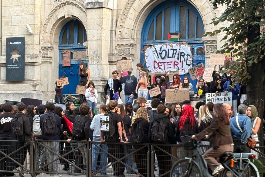 In this photo taken with a smartphone, high school students block the entrance of a Voltaire high school to demand more resources, in Paris, France, Thursday, Oct. 1, 2026. (AP Photo/Nicolas Garriga)
 ...
