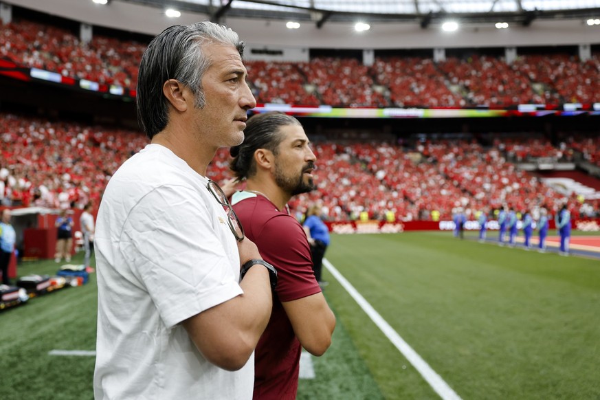 Switzerland's head coach Murat Yakin, left, and Switzerland's assistant coach Davide Calla, right, look during the national anthem prior the World Cup Group B soccer match between Switzerlan ...