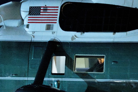 epa12666275 US President Donald J Trump looks out of Marine One on the South Lawn of the White House in Washington, DC, USA, 20 January 2026. President Trump is heading to Davos, Switzerland, to atten ...