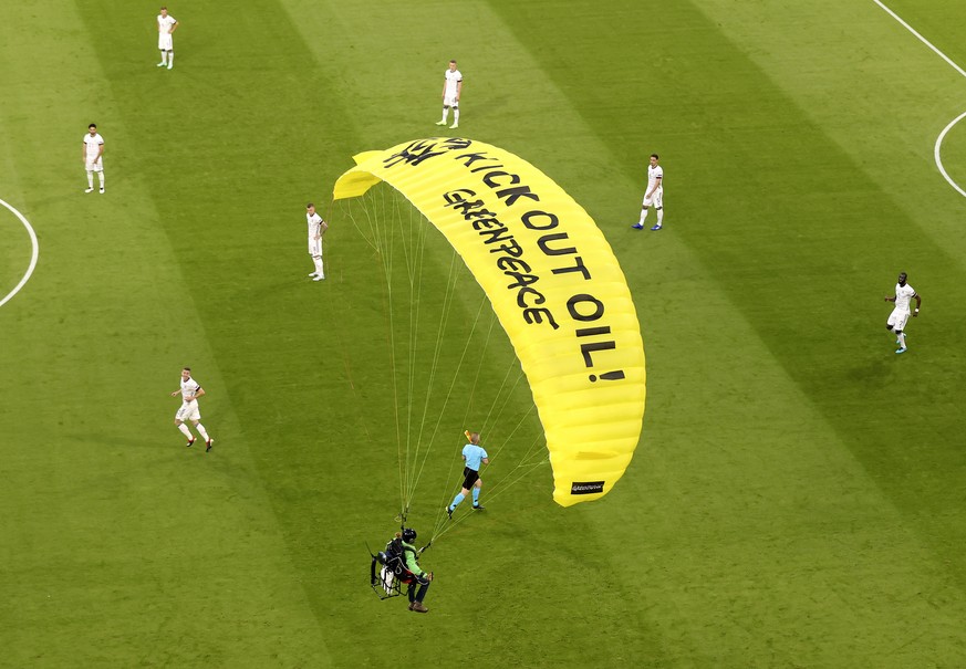 The German players look on as a Greenpeace paraglider lands in the stadium prior to the Euro 2020 soccer championship group F match between France and Germany at the Allianz Arena stadium in Munich, T ...