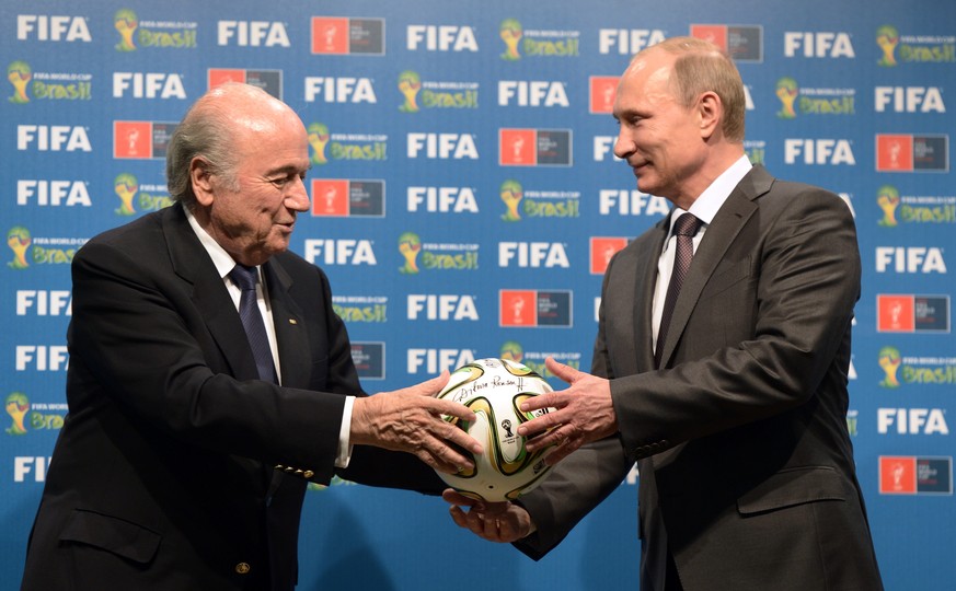FILE - In this file photo taken on Sunday, July 13, 2014, FIFA President Sepp Blatter, left, and Russian President Vladimir Putin hold a soccer ball during the official ceremony of handover to Russia  ...