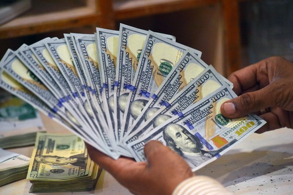 epa10621024 A foreign currency dealer displays US dollars at a money exchange company in Karachi, Pakistan, 11 May 2023. The Pakistani rupee on 11 May recorded all time low against the US dollar with  ...