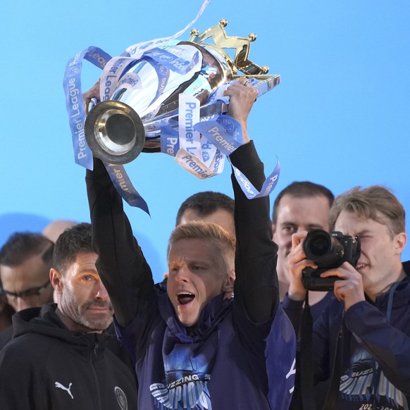 Manchester City&#039;s Oleksandr Zinchenko lifts the trophy on a stage as fans watch the winners parade as the team celebrates winning the English Premier League title in Manchester, England, Monday,  ...