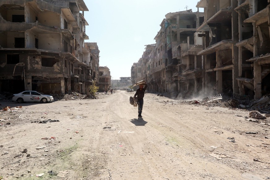 epa09545193 Residents walk on the streets of the war-ravaged Yarmouk Camp for Palestinian refugees in the south of Damascus, Syria, 25 October 2021. The government has recently allowed the entry of pe ...