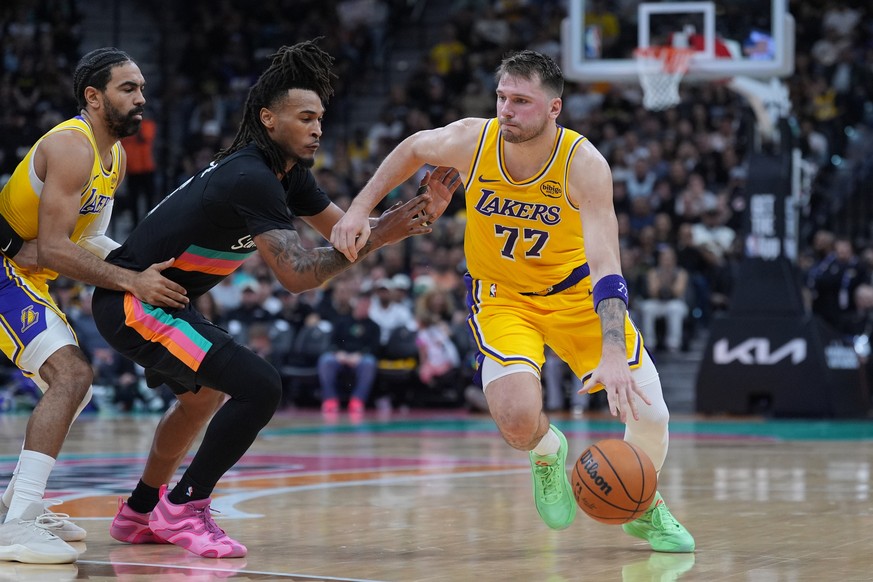 Los Angeles Lakers guard Luka Doncic (77) drives around San Antonio Spurs guard Stephon Castle (5) during the second half of an NBA basketball game in San Antonio, Wednesday, Jan. 7, 2026. (AP Photo/E ...