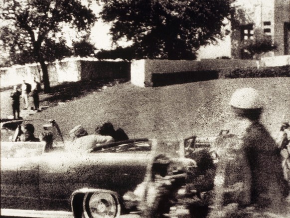 First Lady Jacqueline Kennedy leans over to assist her husband just after he is shot as the Presidential motorcade passes through Dealey Plaza on Elm Street in Dallas, Texas, on November 22, 1963. Gov ...