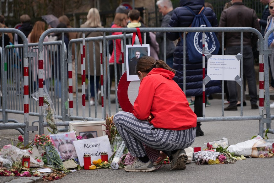 epa11226193 Flowers and portraits of Alexei Navalny are seen as Russians living in Switzerland gather in front of the Russian embassy in Bern to take their vote during the Russian presidential electio ...