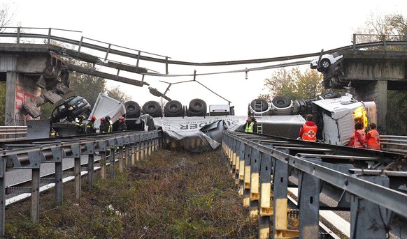 A truck lies on a road after an overpass it was traveling on collapsed, between Milan and Lecco, northern Italy, Friday, Oct. 28, 2016. An overpass north of Milan has collapsed under the weight of a t ...