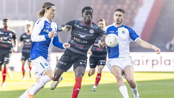 Ayumu Seko (GC) (links) und Maksim Paskotsi (GC) (rechts) kaempfen um den Ball mit Christian Gomis (FCW) (Mitte) im Fussball Meisterschaftsspiel der Swiss Super League zwischen Grasshopper Club Zueric ...