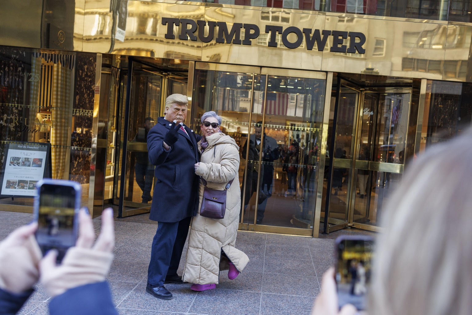 epa11159499 A person poses with a Donald Trump impersonator in front of Trump Tower as seen in New York, New York, USA, 16 February 2024. Judge Arthur Engoron issued the Trump Organization to pay over ...