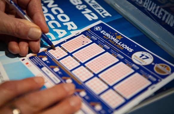 epa08862326 A person plays a EuroMillions grid in Bordeaux, France, 04 December 2020. The jackpot for this draw will reach 200 million euro. Before 2020, the jackpot was capped at 190 million euros. E ...