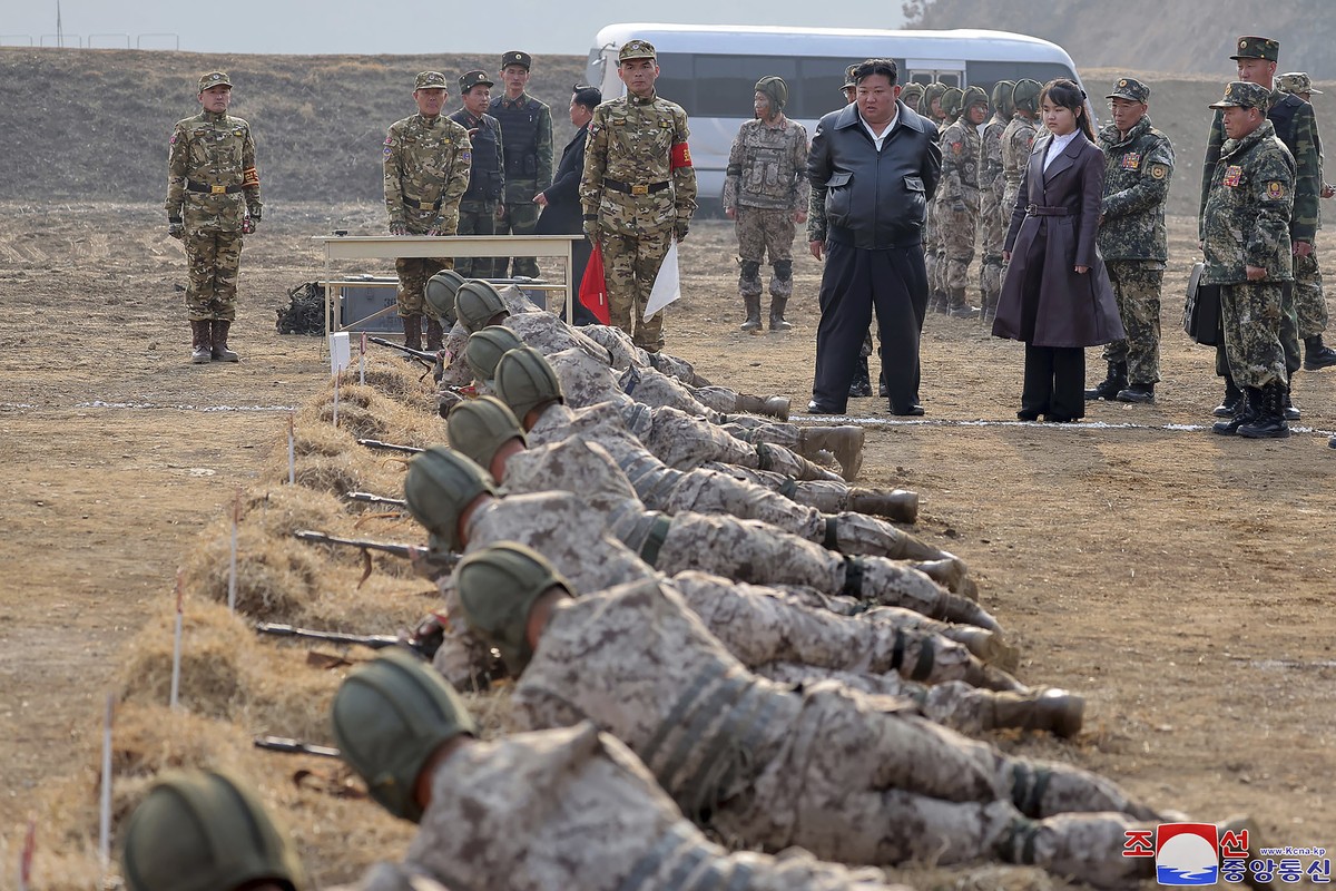 In this photo provided by the North Korean government, North Korean leader Kim Jong Un, standing in front center, and his daughter inspect a training of the Korean People's Army airborne units in ...