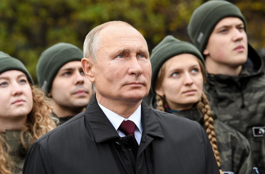 epa08797919 Russian President Vladimir Putin (C) and members of youth organisations attend a flowers-laying ceremony on the National Unity Day at the monument to Kuzma Minin and Dmitry Pozharsky in th ...