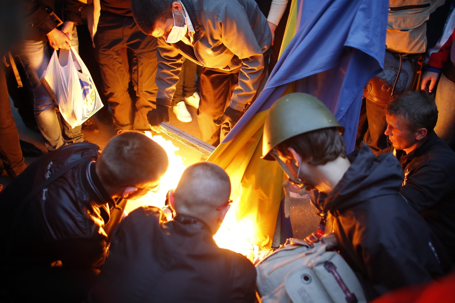 Prorussische Separatisten verbrennen eine ukrainische Flagge in Donezk.