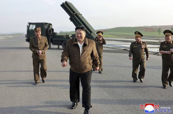 In this photo provided by the North Korean government, North Korean leader Kim Jong Un, center, supervises a test firing of a new multiple rocket launch system at an undisclosed place in North Korea o ...