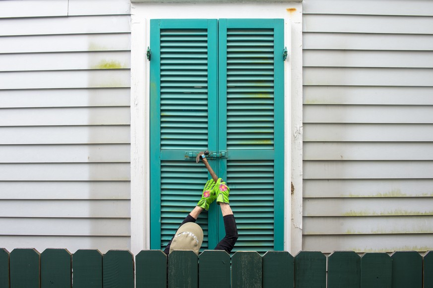 Storm shutters are hammered closed on a 100-year-old house, Friday, August 27, 2021, in New Orleans, as residents prepare for Hurricane Ida. (Chris Granger/The Times-Picayune/The New Orleans Advocate  ...