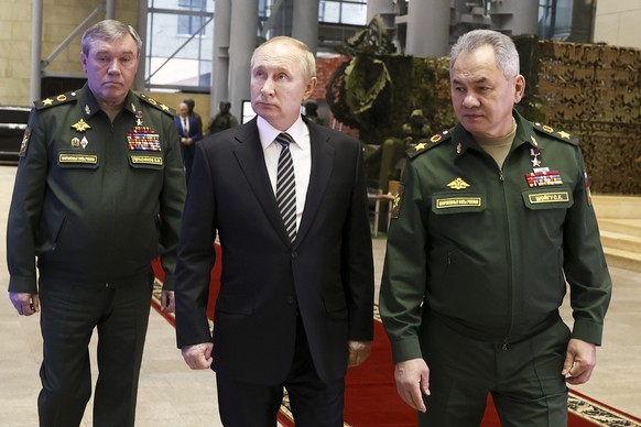 FILE - Russian President Vladimir Putin, center, escorted by Russian Defense Minister Sergei Shoigu, right, and General Staff Valery Gerasimov walk after attending an extended meeting of the Russian D ...