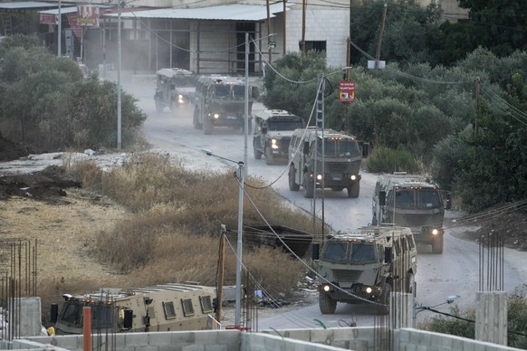 A convoy of army vehicles is seen during a military raid in the Jenin refugee camp, a militant stronghold, in the occupied West Bank, Tuesday, July 4, 2023. Palestinian health officials said at least  ...