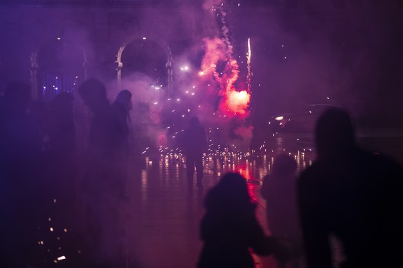 epa10384656 People watch fireworks during New Year&#039;s Eve celebrations, on the federal square (Bundesplaetz), in Bern, Switzerland, 01 January 2023. EPA/ANTHONY ANEX