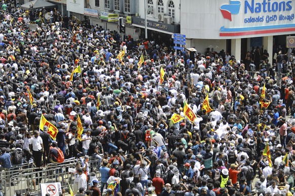 Protesters, some holding Sri Lankan flags, gather in a street leading to the presidents official residence in Colombo, Sri Lanka, Saturday, July 9, 2022. Sri Lankan protesters demanding that President ...