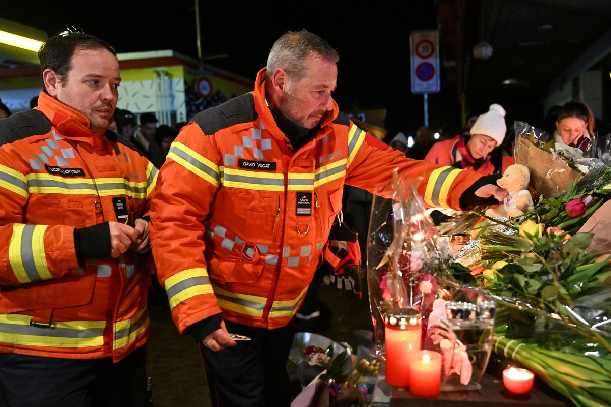 CRANS-MONTANA, SWITZERLAND - JANUARY 01: Firefighters gather to leave flowers and candles at the scene after a fire broke out overnight at Le Constellation bar on January 01, 2026 in Crans-Montana, Sw ...