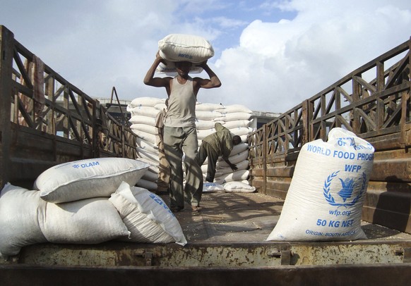FILE - In this Monday, Aug. 8, 2011 file photo, laborers unload a consignment of food aid from the World Food Program (WFP) in Mogadishu, Somalia. The World Food Program on Friday, Oct. 9, 2020 won th ...